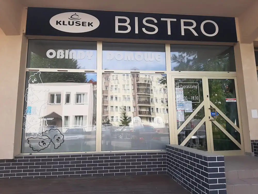 Witryna Bistro Klusek: czarny szyld KLUSEK BISTRO i napis Obiady domowe na szybie